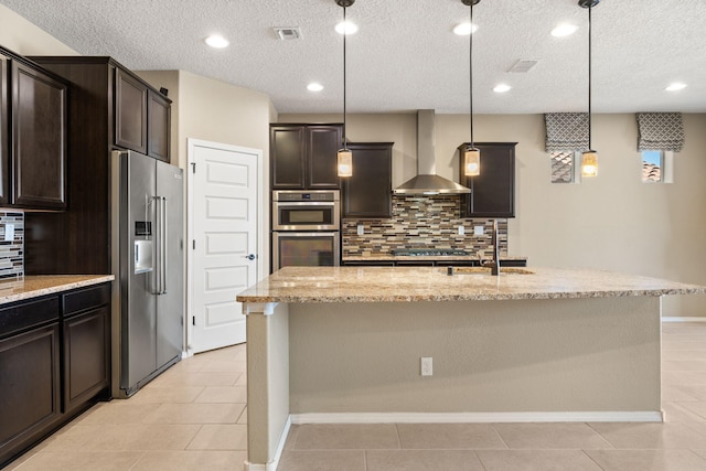 kitchen with decorative backsplash, wall chimney exhaust hood, stainless steel appliances, and pendant lighting