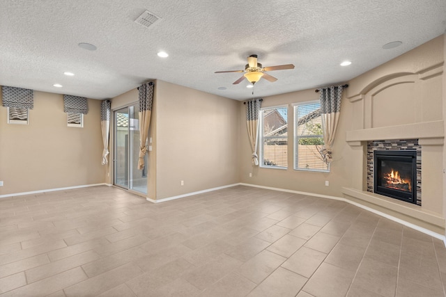 unfurnished living room with a textured ceiling, ceiling fan, and a fireplace