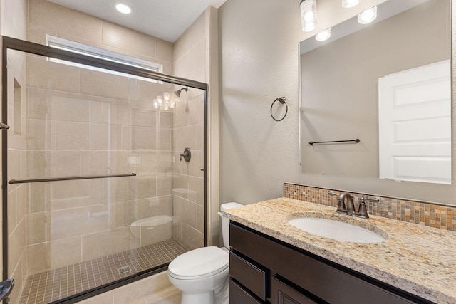 bathroom with tasteful backsplash, vanity, an enclosed shower, and toilet