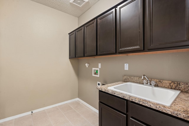 laundry area with hookup for an electric dryer, a textured ceiling, washer hookup, cabinets, and sink