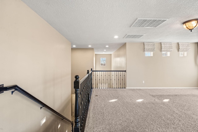 interior space featuring a textured ceiling and carpet flooring