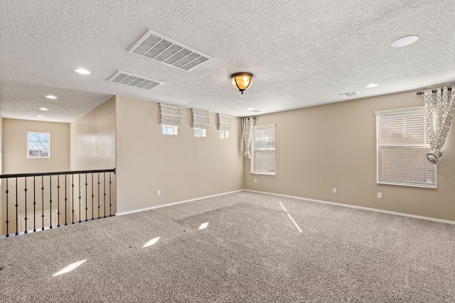 spare room featuring a textured ceiling and carpet floors