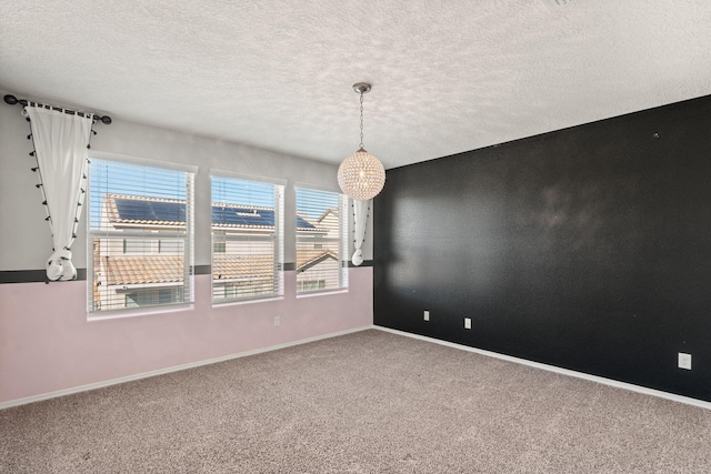 empty room with carpet, a healthy amount of sunlight, and a textured ceiling