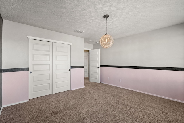 empty room featuring a textured ceiling and carpet floors