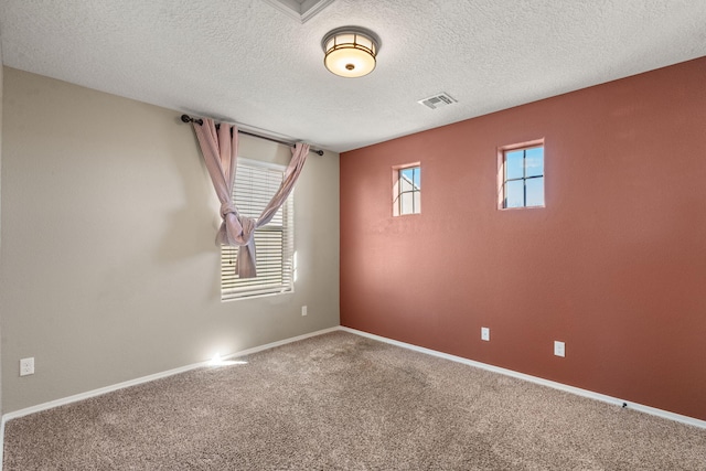 unfurnished room featuring a textured ceiling and carpet flooring