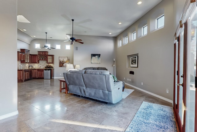 living room with ceiling fan and a high ceiling