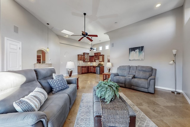 living room with ceiling fan and a high ceiling