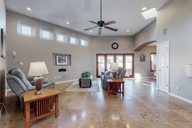 living room featuring ceiling fan and a high ceiling