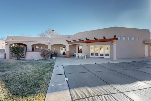 rear view of property with a yard and a patio