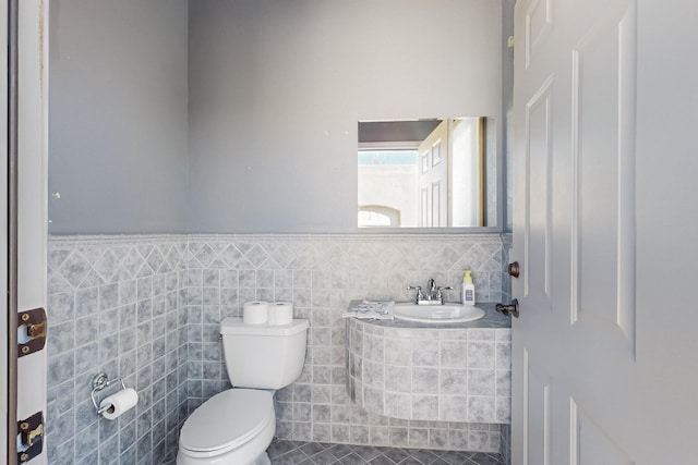 bathroom featuring sink, tile walls, toilet, and tile patterned flooring