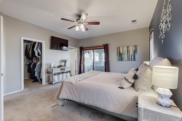 carpeted bedroom featuring a spacious closet, a closet, and ceiling fan