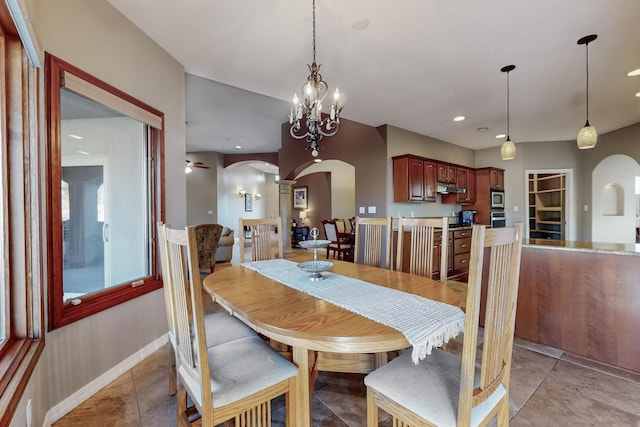 tiled dining room featuring ceiling fan with notable chandelier