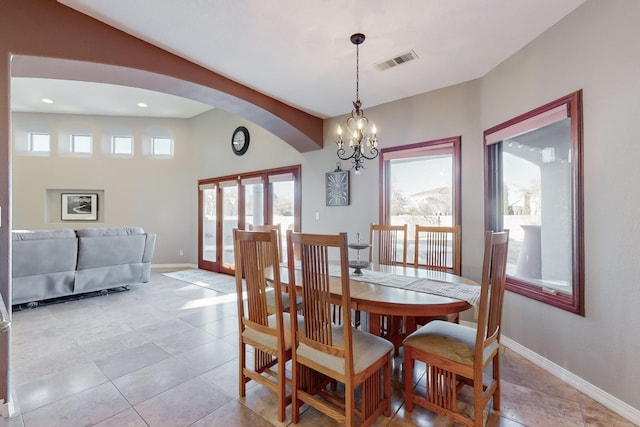 tiled dining room featuring a chandelier