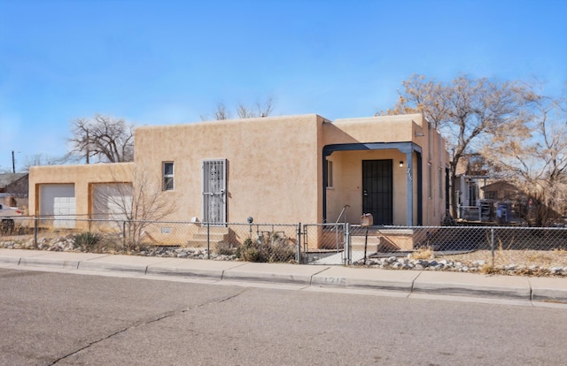 pueblo revival-style home with a garage