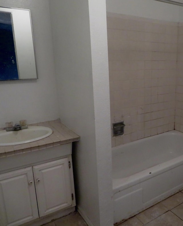 bathroom with a bath, vanity, and tile patterned flooring