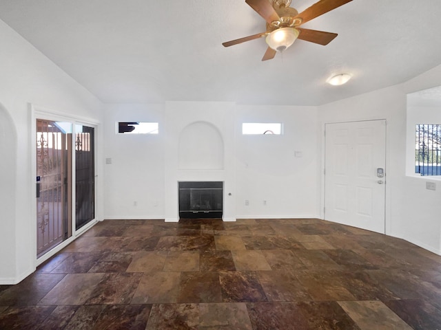 unfurnished living room with lofted ceiling, ceiling fan, and a large fireplace