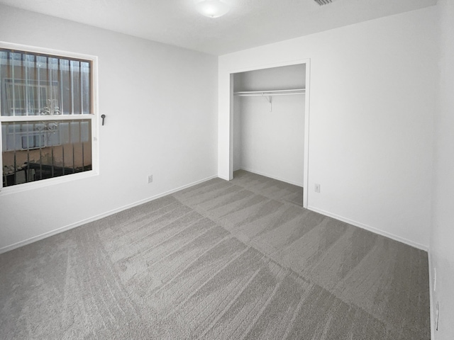 unfurnished bedroom featuring carpet and a closet