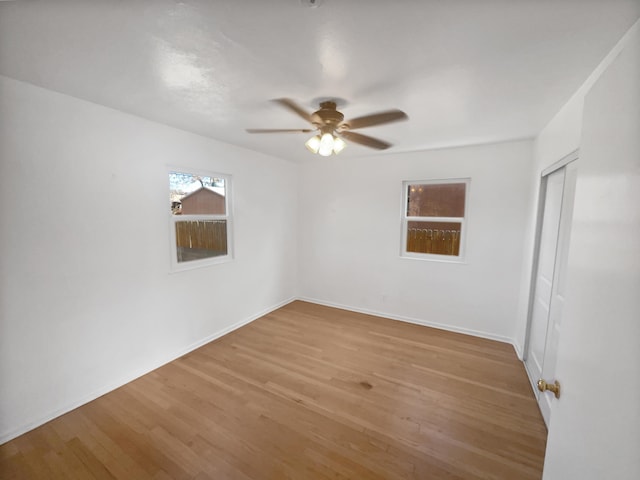 unfurnished room with ceiling fan, baseboards, and wood finished floors