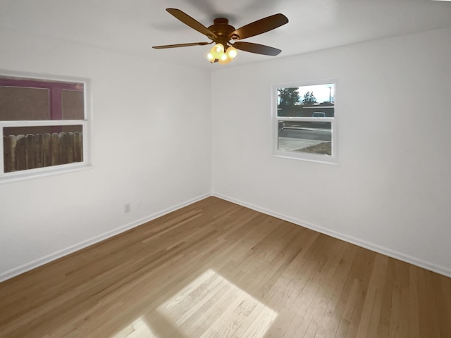 empty room with ceiling fan, baseboards, and wood finished floors