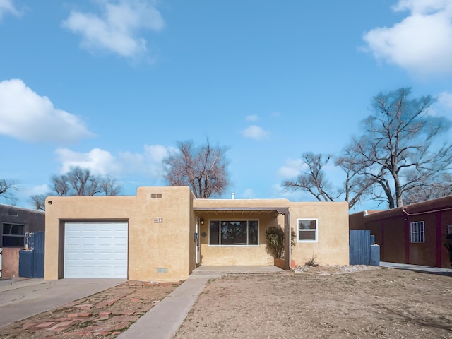 pueblo-style house featuring a garage