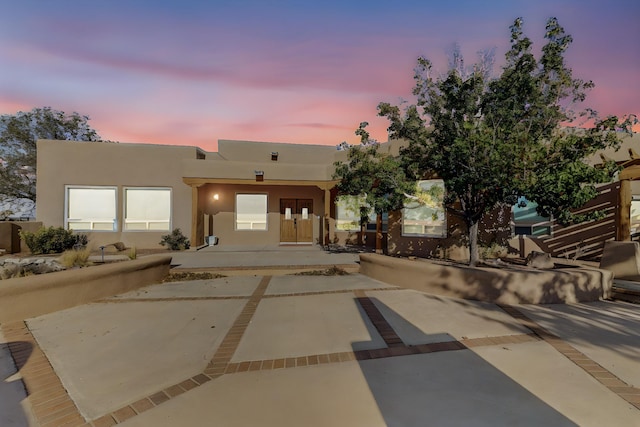 pueblo-style home with a patio