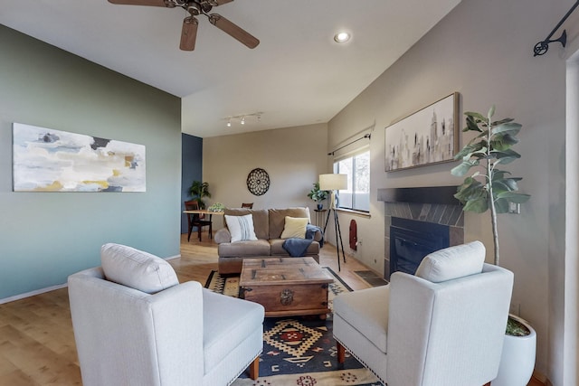 living room with light wood-type flooring, ceiling fan, and track lighting