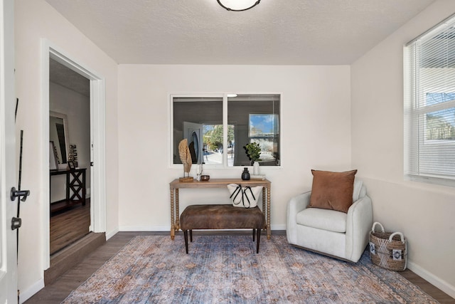 living area with hardwood / wood-style flooring, a textured ceiling, and a wealth of natural light