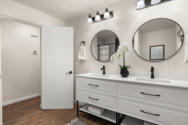 bathroom featuring hardwood / wood-style flooring, vanity, a textured ceiling, and a shower with curtain