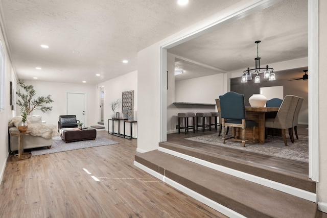 dining room with a notable chandelier, wood-type flooring, and a textured ceiling