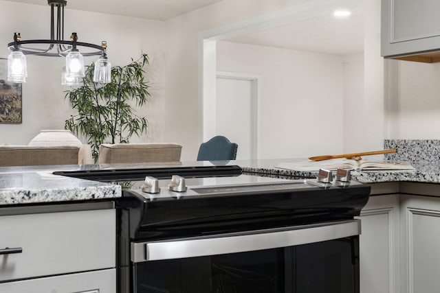 kitchen featuring light stone countertops, range with electric cooktop, and white cabinets