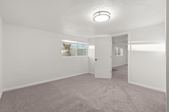 carpeted spare room featuring plenty of natural light and a textured ceiling