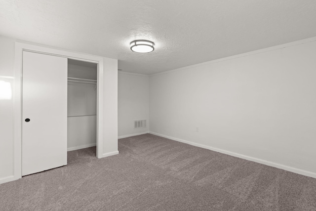 unfurnished bedroom with carpet floors, a closet, and a textured ceiling