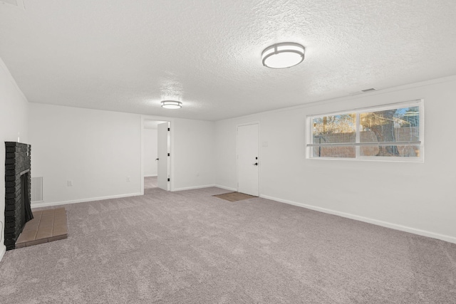 unfurnished living room featuring a fireplace, a textured ceiling, and carpet