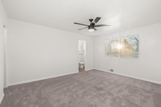 empty room with ceiling fan, carpet flooring, and a textured ceiling