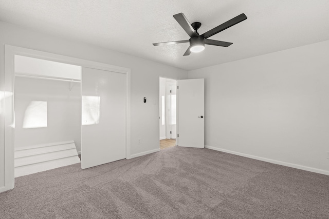 unfurnished bedroom with ceiling fan, a closet, a textured ceiling, and carpet