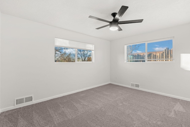 unfurnished room with a textured ceiling, ceiling fan, and carpet