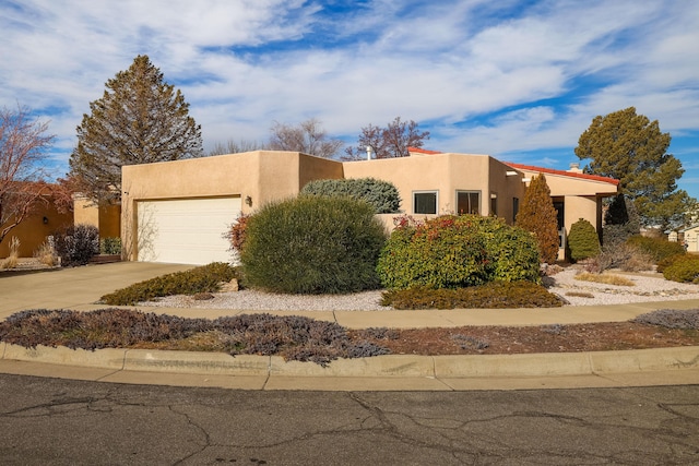 pueblo revival-style home featuring a garage