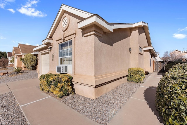 view of side of property featuring cooling unit and a garage