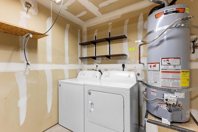 washroom featuring strapped water heater and washing machine and clothes dryer