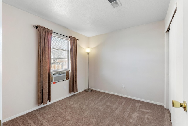 carpeted spare room with cooling unit and a textured ceiling