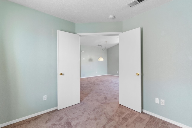 carpeted spare room featuring a textured ceiling