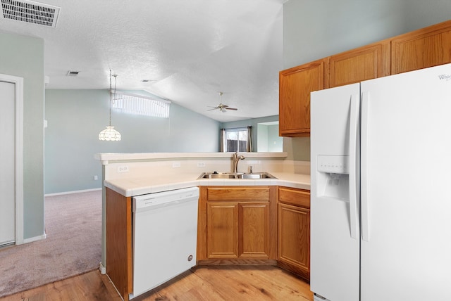 kitchen with white appliances, sink, hanging light fixtures, vaulted ceiling, and ceiling fan