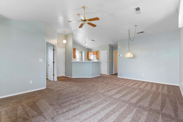 unfurnished living room featuring a textured ceiling, ceiling fan, lofted ceiling, and carpet floors