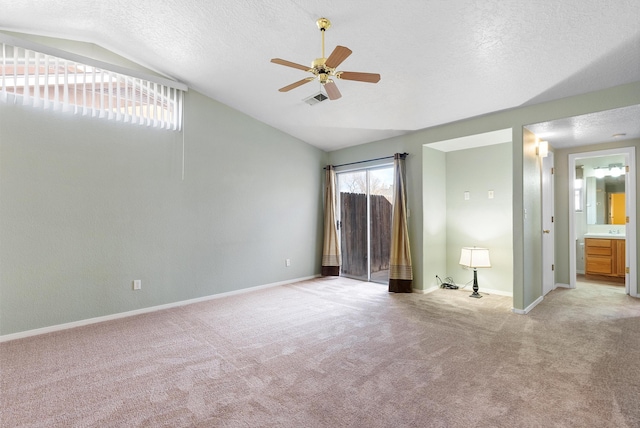 carpeted spare room with a textured ceiling, ceiling fan, and lofted ceiling