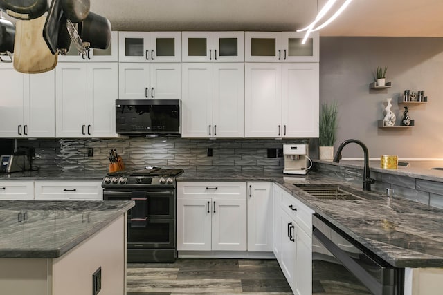 kitchen featuring sink, white cabinets, tasteful backsplash, and stainless steel range with gas stovetop