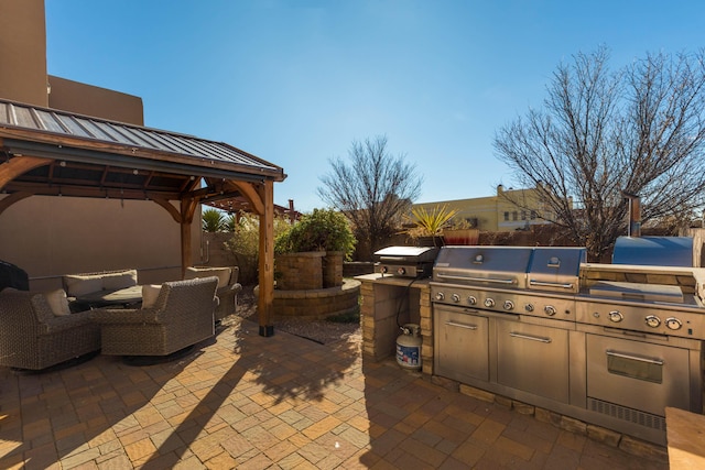 view of patio featuring exterior kitchen, outdoor lounge area, a gazebo, and a grill