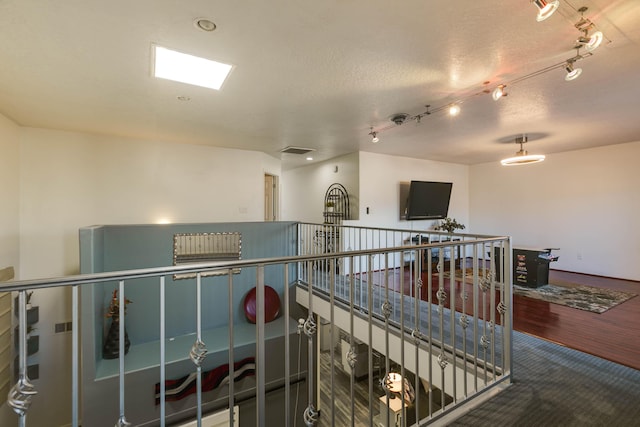 hall with carpet floors and a textured ceiling