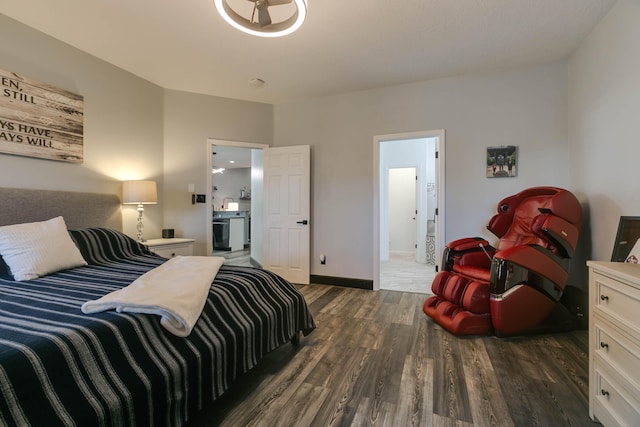 bedroom with connected bathroom and dark hardwood / wood-style floors