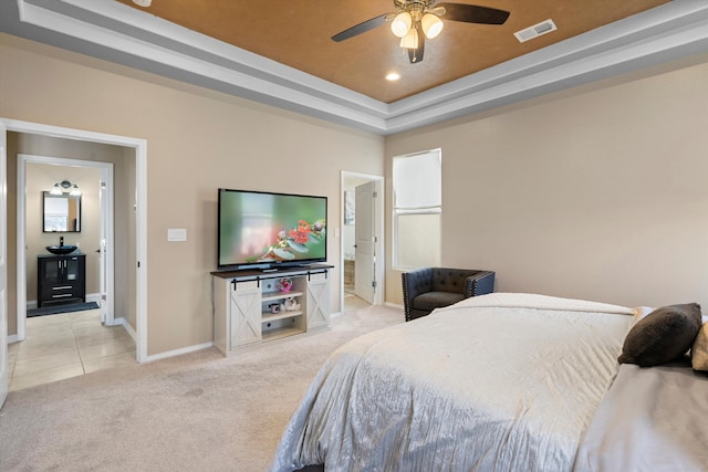 carpeted bedroom with ceiling fan and a tray ceiling