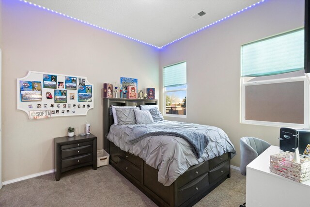 bedroom featuring visible vents, light carpet, and baseboards